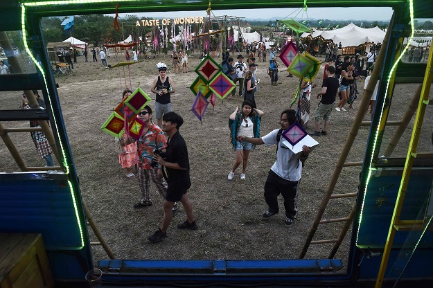 This picture taken on February 17, 2017 shows festivalgoers checking out the Molam Bus at the Wonderfruit music festival in Chonburi. PHOTO: AFP