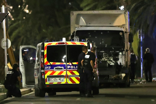 Police stand near a truck that ploughed into a crowd leaving a fireworks display in the French Riviera town of Nice on July 14, 2016. PHOTO: AFP