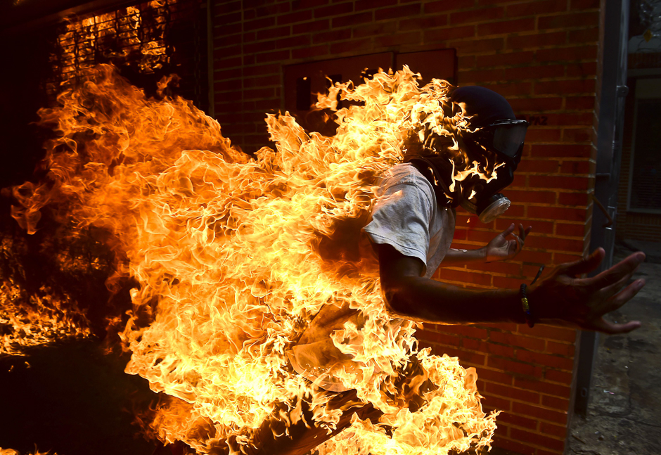 An opposition activist suddenly turned into a human torch runs upon clashing with riot police during a protest against Venezuelan President Nicolas Maduro, in Caracas. PHOTO: AFP