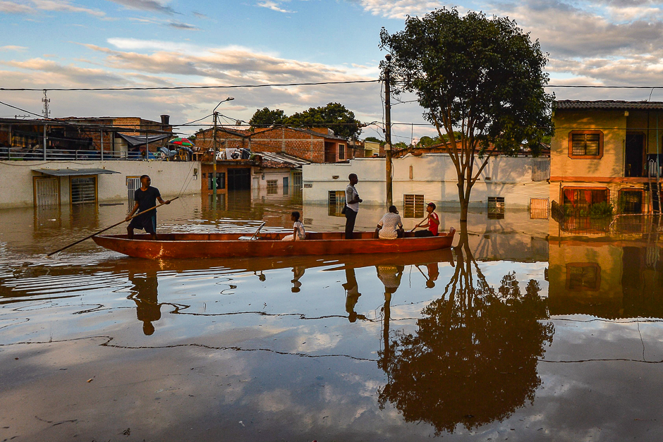 People are transported in a canoe along a flooded street in Cali, Colombia. PHOTO: AFP