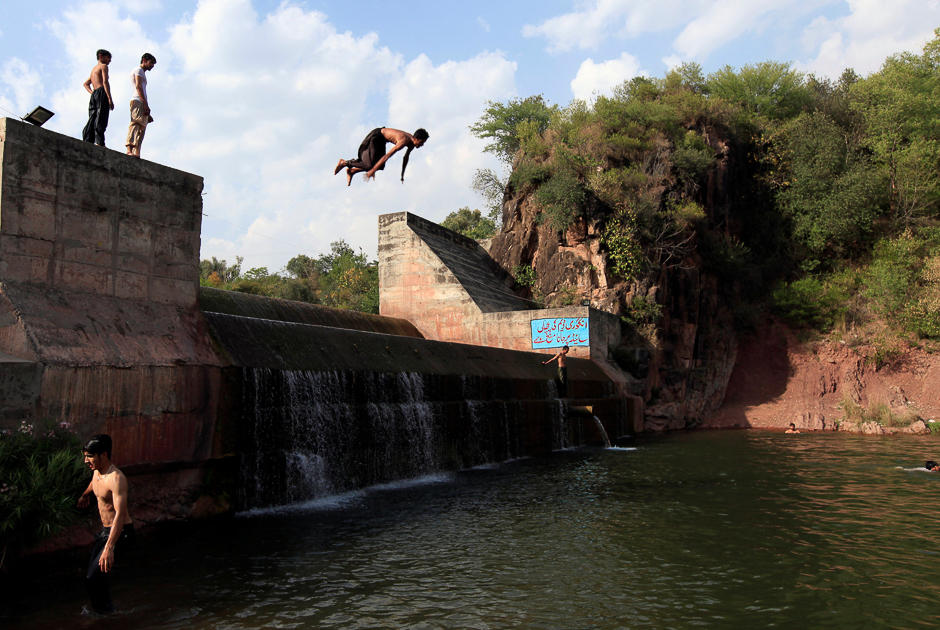 A man jumps in to a stream to cool off from the heat on a hot summer day on the outskirts of Islamabad. PHOTO: REUTERS