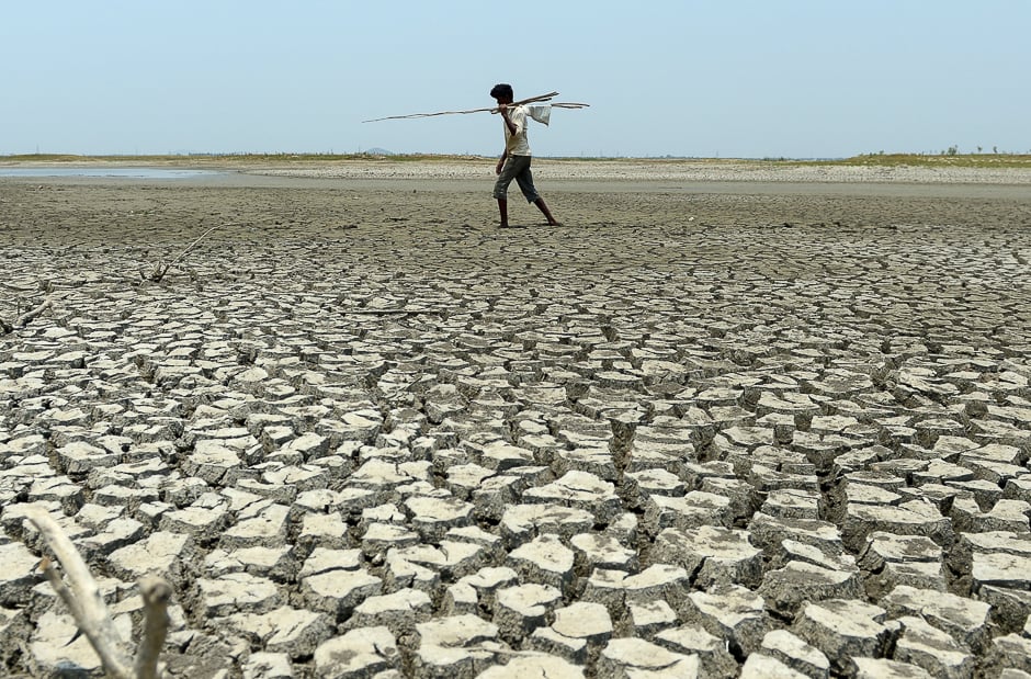 An Indian man walks over the parched bed of a reservoir on the outskirts of Chennai. PHOTO: AFP