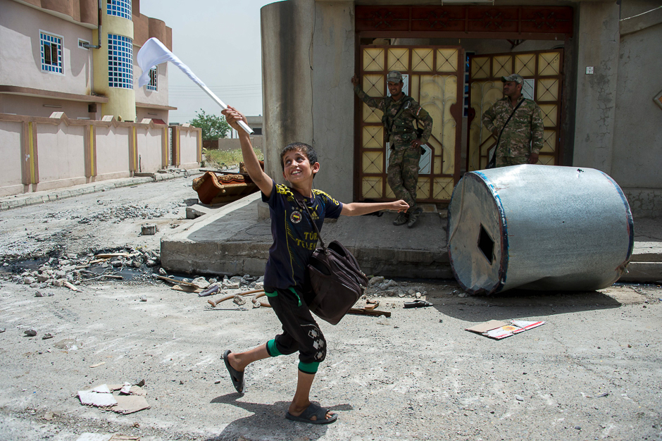 An Iraqi boy carries a white flag as he evacuates his home as Iraqi forces advance in the northwestern al-Haramat neighbourhood of Mosul, during the ongoing offensive to retake the area from Islamic State (IS) group fighters. PHOTO: AFP