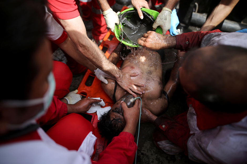 Rescue workers try to resuscitate a coal miner after he was pulled out from a mine in Azadshahr, in northern Iran, following an explosion leaving dozens of miners trapped. PHOTO: AFP