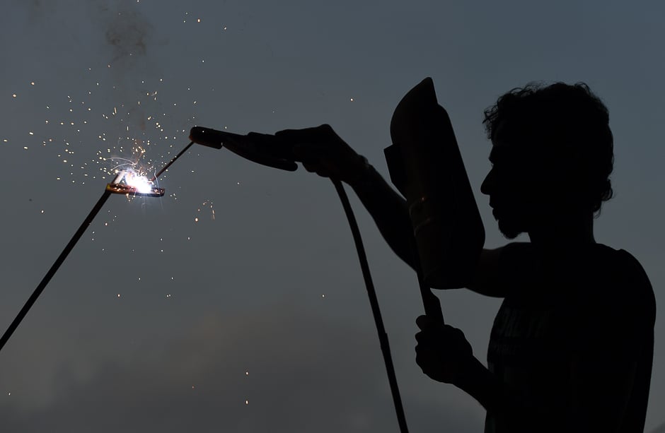 A Sri Lankan ironworker welds material at a building site in Colombo. PHOTO: REUTERS