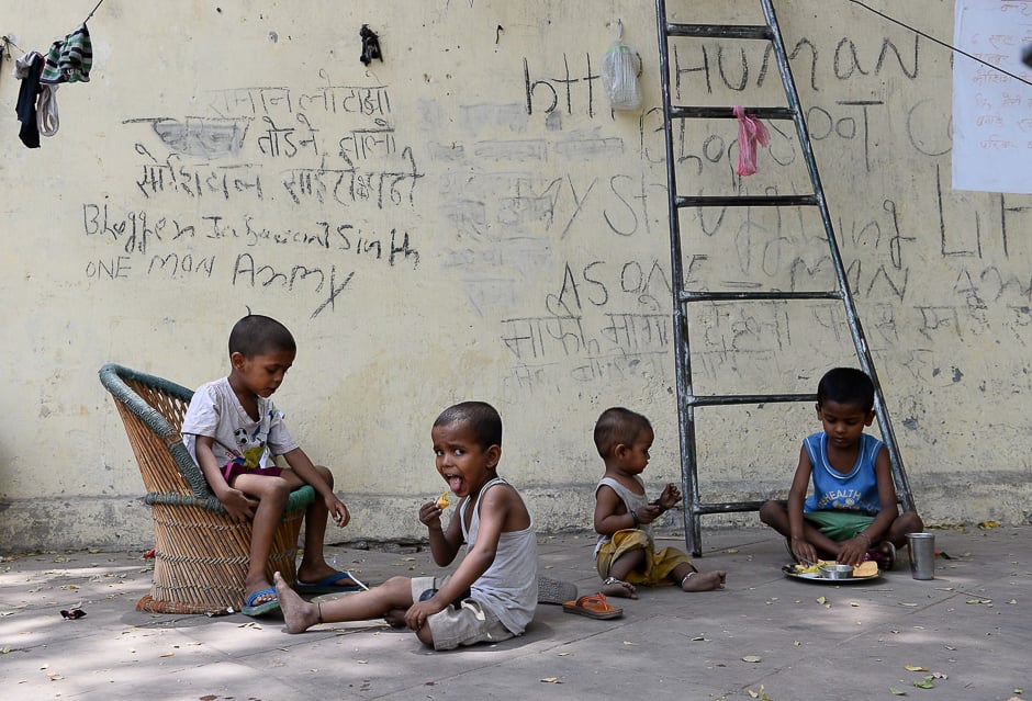 Indian children eat food on a foothpath in New Delhi. PHOTO: AFP