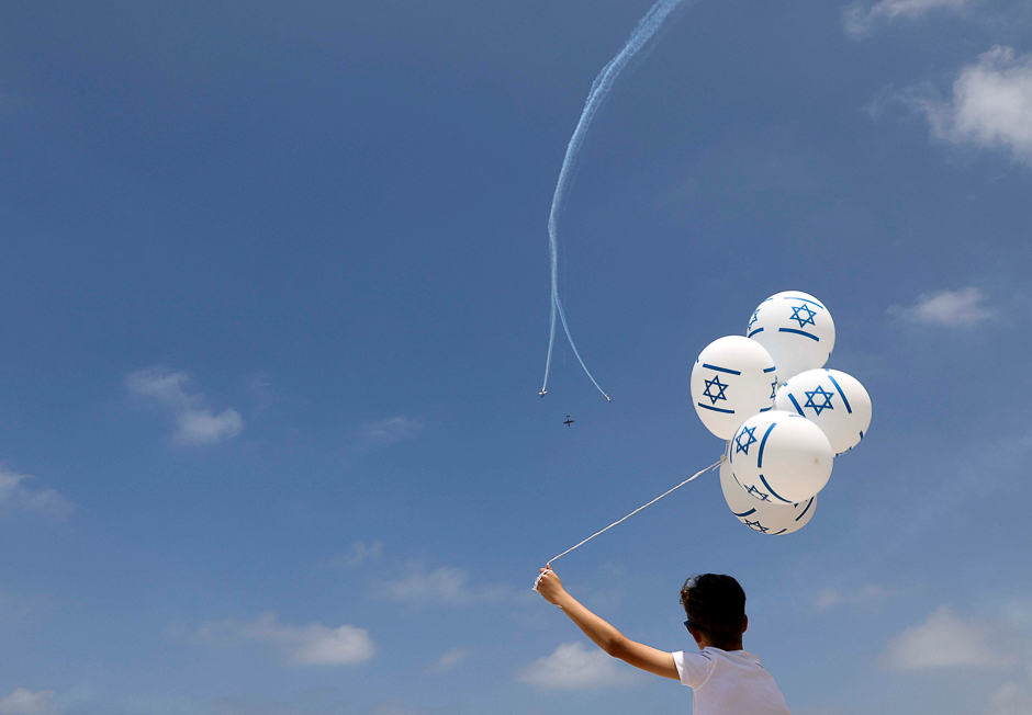 A boy watches the Israeli Air Force Aerobatic team fly over the Mediterranean Sea during an aerial show as part of the celebrations for Israel's Independence Day marking the 69th anniversary of the creation of the state in Tel Aviv, Israel. PHOTO: REUTERS