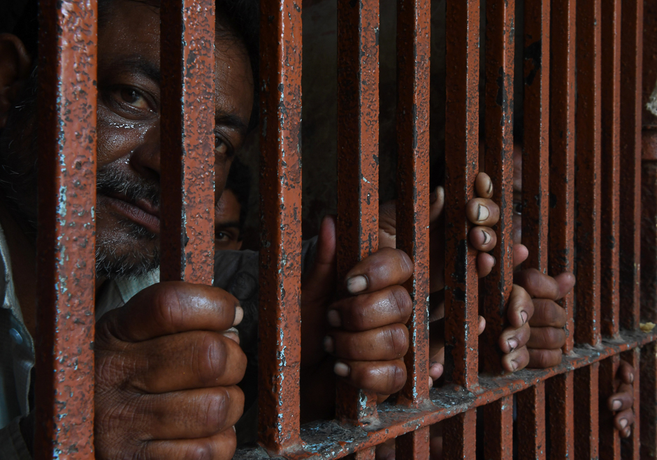 Arrested Indian fishermen look out from a lockup at a police station in Karachi. PHOTO: AFP