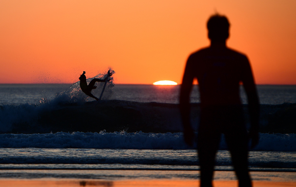 England's Reubyn Ash is seen in silhouette as he gets ready for the heat 77 - Round 2 on May 24, 2017 in Biarritz, southwestern France, during the 2017 ISA World Surfing Games.. PHOTO: AFP