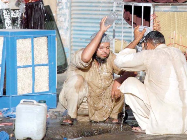 Labourers taking a bath outside a shop at Shoba Bazaar to get relief from the scorching hot day in Peshawar. PHOTO: APP