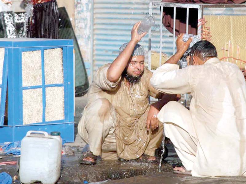 labourers taking a bath outside a shop at shoba bazaar to get relief from the scorching hot day in peshawar photo app