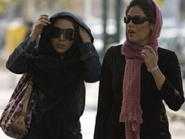 iranian women adjust their headscarves as they walk on a street photo reuters