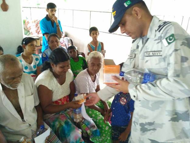 a pakistan navy officer distributes edibles among the displaced people of sri lanka 039 s flood affected areas photo pakistan navy