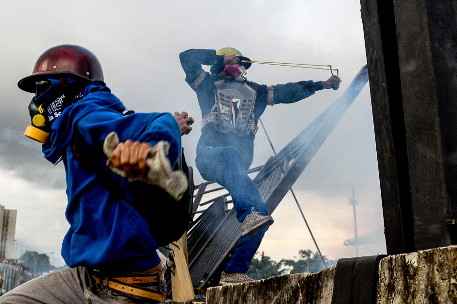 Opposition activists and riot police clash during a protest against President Nicolas Maduro, in Caracas. PHOTO: AFP