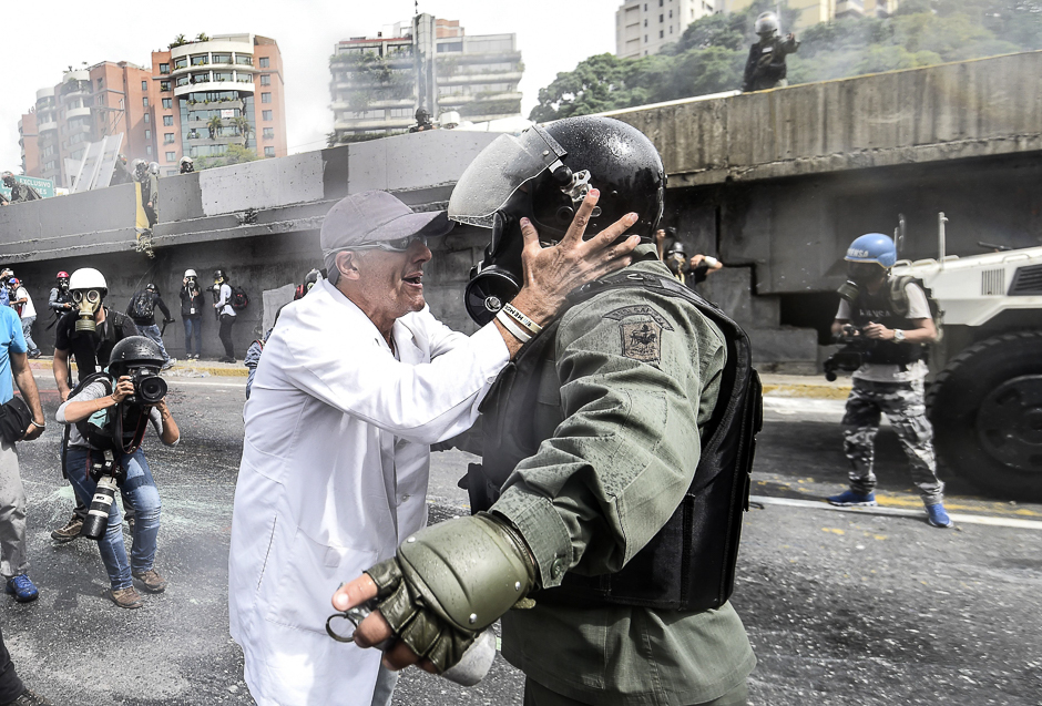An opposition demonstrator argues with a National Guard riot policeman during a health care personnel march in Caracas. PHOTO: AFP