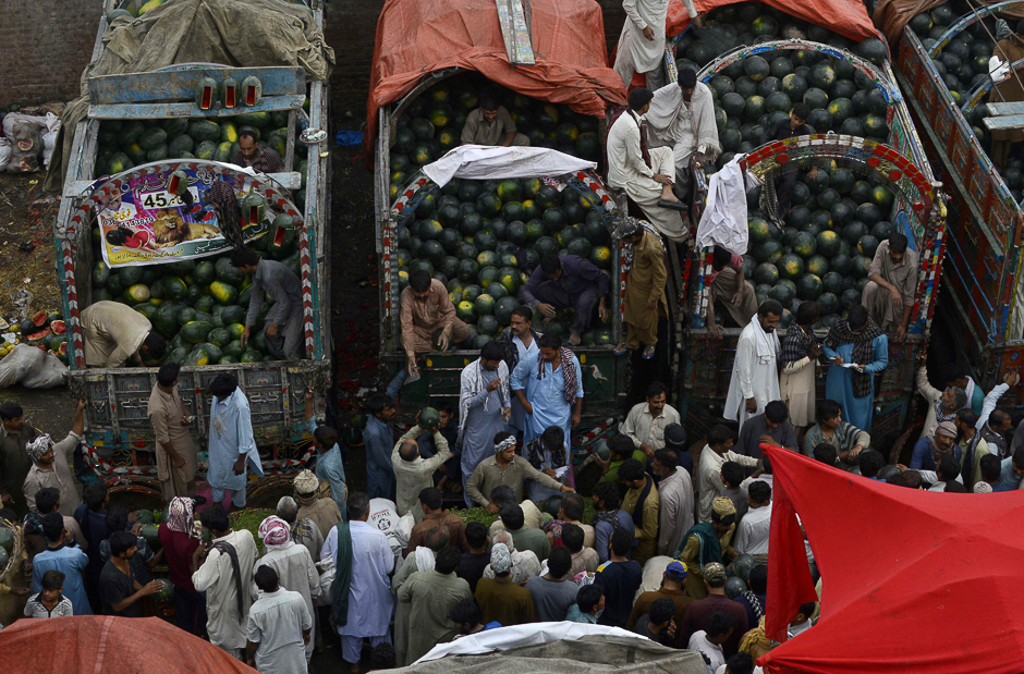 Pakistani farmers and traders gather as they sell watermelons at a fruit market in Lahore. PHOTO: AFP