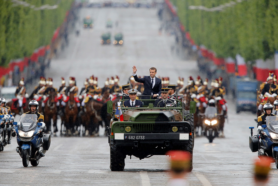 Newly elected French president Emmanuel Macron waves as he parades in a military car on the Champs Elysees avenue, after his formal inauguration ceremony in Paris. PHOTO: AFP