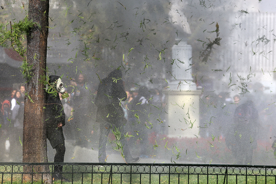 Demonstrators take cover as they clash with riot police during a students' march for a better education reform in Santiago, Chile. PHOTO: REUTERS