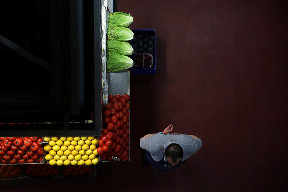 A grocer waits for customers next to his stand at a food market in Madrid, Spain. PHOTO: REUTERS