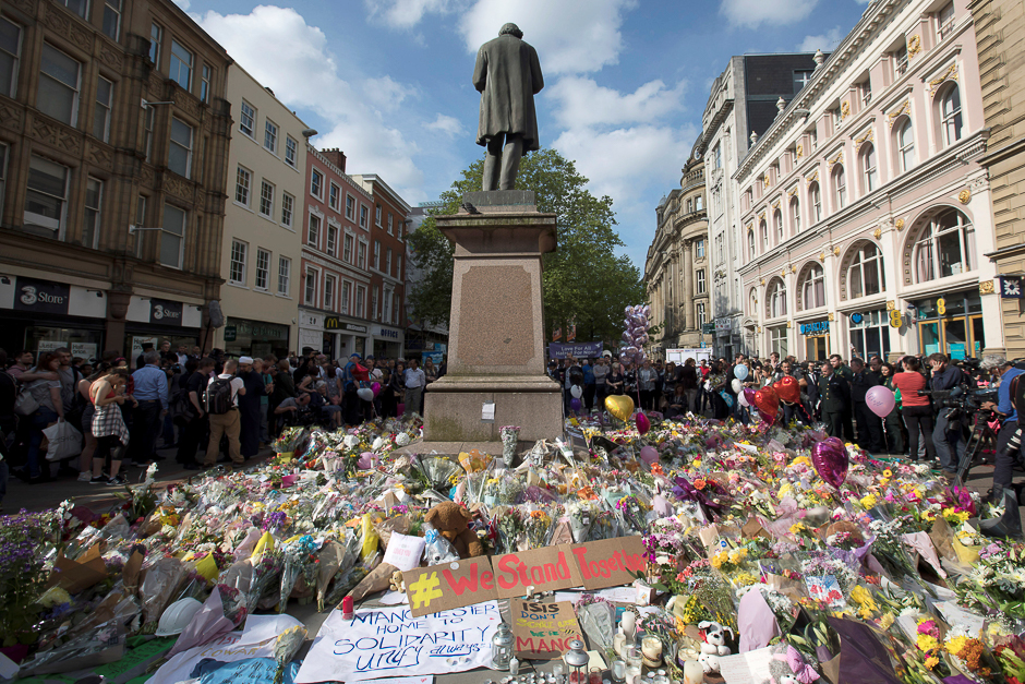 Messages and floral tributes left for the victims of the attack on Manchester Arena lie around the statue in St Ann's Square in central Manchester. PHOTO: REUTERS