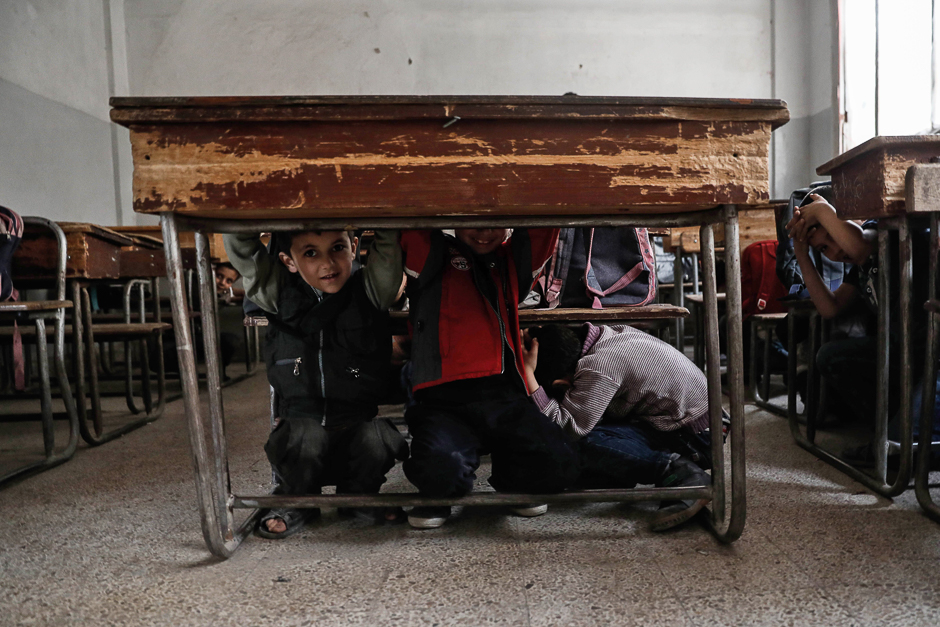 Schoolchildren learn how to protect themselves in case of a bombardment during a war safety awareness class as part of a campaign conducted by the Syrian civil defence, known as The White Helmets, in the rebel-held area of Harasta, on the northeastern outskirts of the capital Damascus. PHOTO: AFP