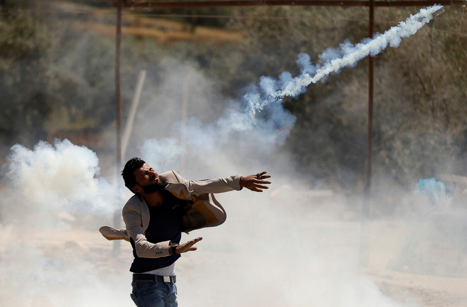 A Palestinian protester hurls back a tear gas canister fired by Israeli troops during clashes in the West Bank village of Beita, near Nablus. PHOTO: REUTERS