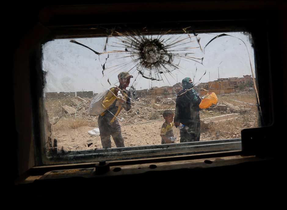 Displaced Iraqis flee during a fight between Iraqi Counter Terrorism Service (CTS) forces and Islamic State militants in western Mosul, Iraq. PHOTO: REUTERS