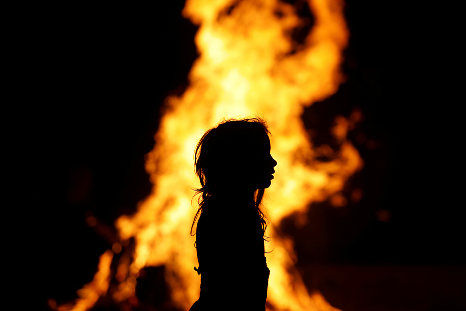 An Ultra-Orthodox Jewish girl stands around a bonfire as she celebrates the Jewish holiday of Lag Ba'Omer in the city of Ashdod, Israel. PHOTO: REUTERS