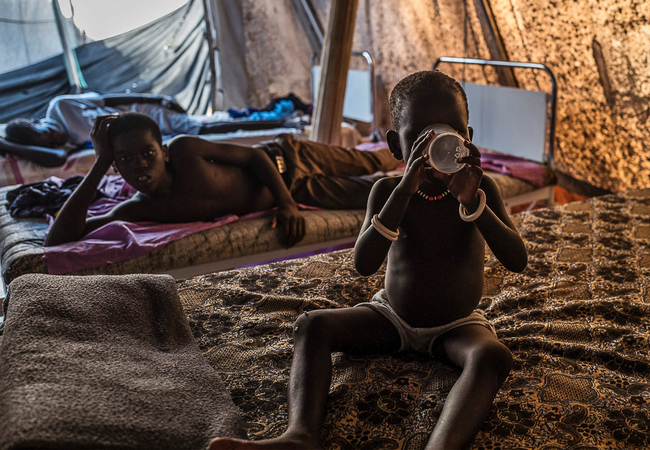 A child suffering from cholera drinks water at a specialized hospital located near the Mingkaman Internally Displaced People (IDP) camp in Mingkaman. PHOTO: AFP