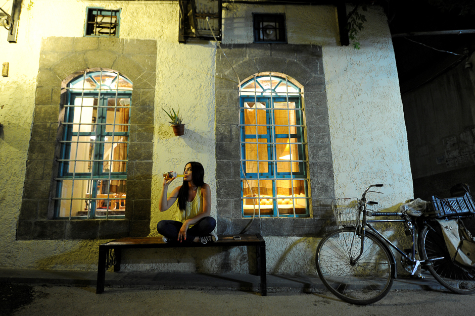 Fine arts graduate Marla Awad, who works at an import and export company, poses for a photograph outside a pub in Old Damascus, Syria. PHOTO: REUTERS