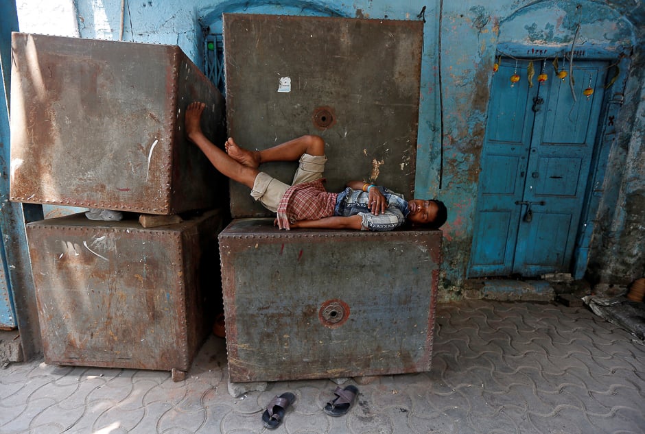 A man sleeps on a metal water storage tank on a hot summer day in Kolkata, India. PHOTO: REUTERS