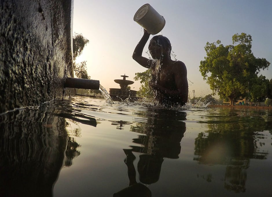 An Indian man bathes in a decorative pool in the gardens surrounding the India Gate monument in New Delhi. PHOTO: AFP