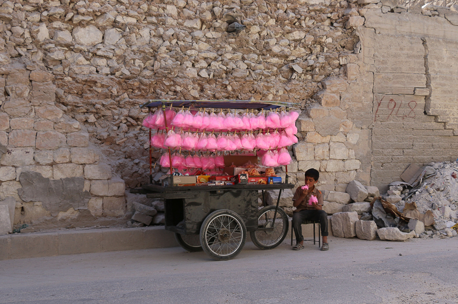 A Syrian child eats candy floss while selling it on a street cart in the Syrian city of al-Bab in the northern Aleppo province. PHOTO: AFP