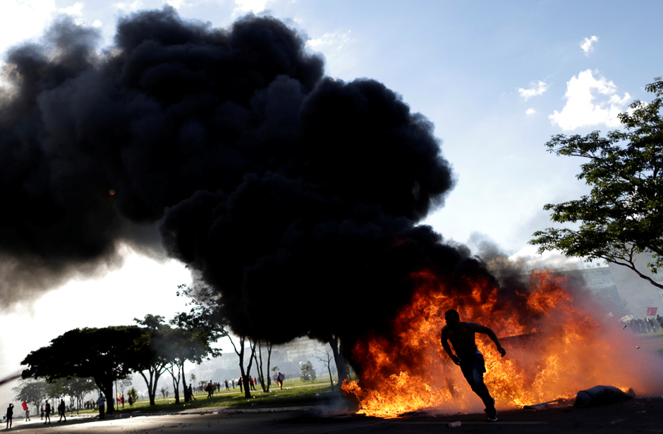 A demonstrator runs near a burning barricade during a protest against President Michel Temer and the latest corruption scandal to hit the country, in Brasilia, Brazil. PHOTO: REUTERS