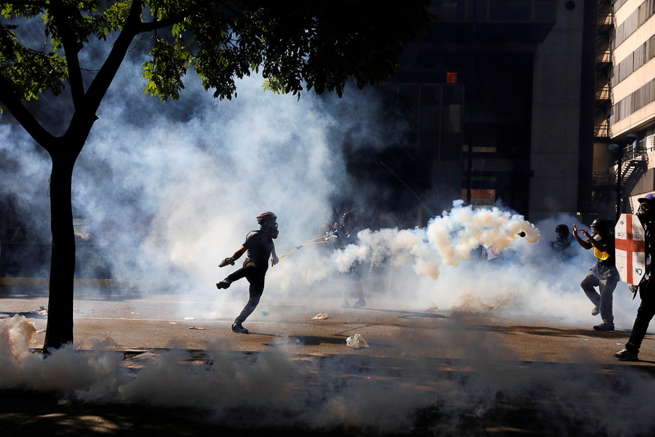 Opposition supporters clash with riot security forces while rallying against President Nicolas Maduro in Caracas, Venezuela. PHOTO: REUTERS