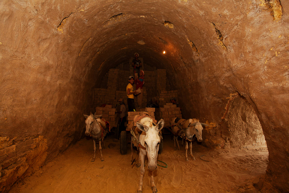 Workers stack bricks inside an oven at a brick factory near the central Iraqi shrine city of Najaf. PHOTO: AFP