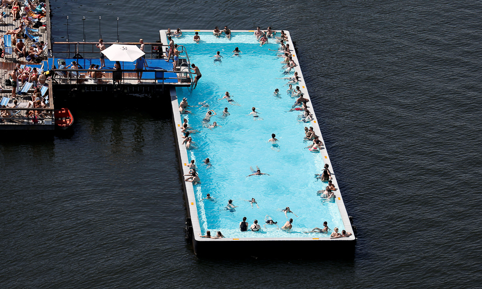 People enjoy the warm sunny weather in the futuristically designed 'Badeschiff' (Pool ship) on the Spree river in Berlin. PHOTO: REUTERS