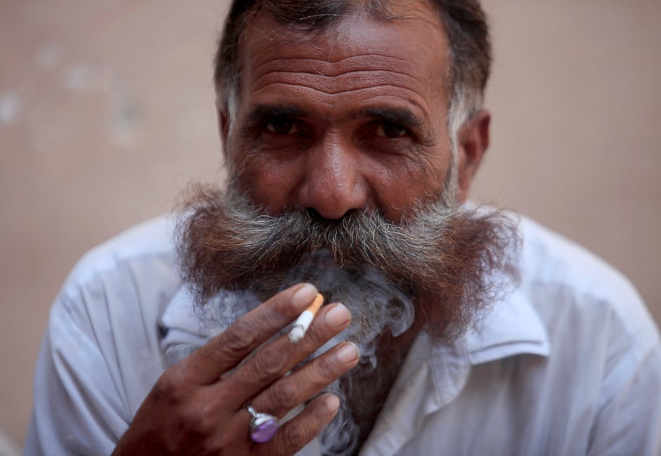 A man smokes a cigarette in a market in Islamabad. PHOTO: REUTERS