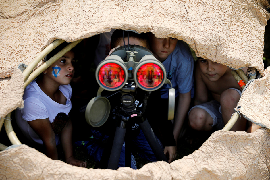 Israeli children look through binoculars during a display of Israeli Defence Forces equipment and abilities, as part of the celebrations for Israel's Independence Day marking the 69th anniversary, in the southern city of Sderot, Israel. PHOTO: REUTERS