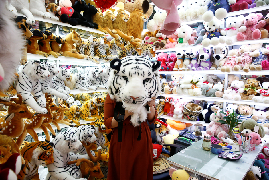 A staff member holds up a toy tiger head as she poses for a picture in a stall at the Yiwu Wholesale Market in Yiwu, Zhejiang province, China. PHOTO: REUTERS