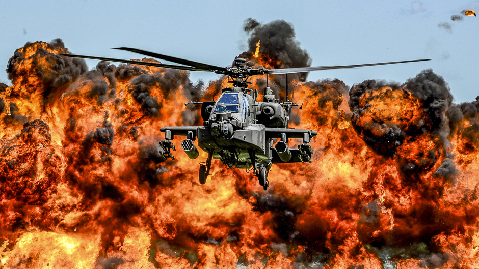 An AH-64D Apache attack helicopter flies in front of a wall of fire during the South Carolina National Guard Air and Ground Expo at McEntire Joint National Guard Base, South Carolina, US. PHOTO: REUTERS