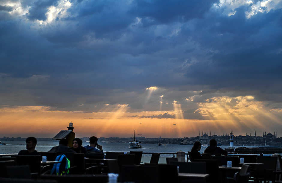 People enjoy the seaside at a cafe as the sun sets in Kadikoy, Istanbul. PHOTO: AFP