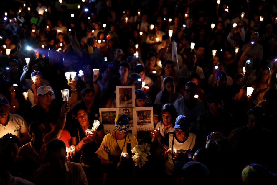 Opposition supporters hold candles while participating in a candlelight rally against President Nicolas Maduro in Caracas, Venezuela. PHOTO: REUTERS