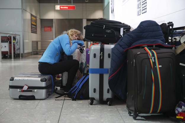 A traveller sleeps next to luggage at Heathrow Airport Terminal 5 after British Airways flights where cancelled at Heathrow Airport in west London on May 27, 2017.  PHOTO: AFP