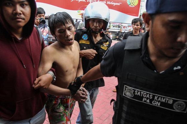 A plainclothes policeman (L) detains a prisoner who escaped from the Sialang Bungkuk jail in Pekanbaru on Indonesia's Sumatra island, May 5, 2017 PHOTO: REUTERS