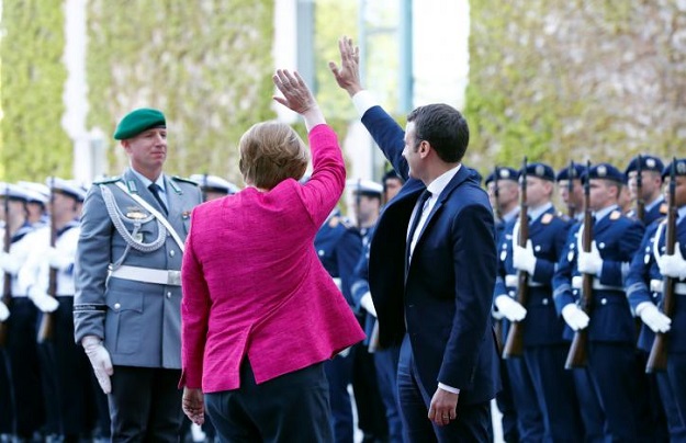German Chancellor Angela Merkel and French President Emmanuel Macron greet at a ceremony at the Chancellery in Berlin, Germany, May 15, 2017. PHOTO: REUTERS