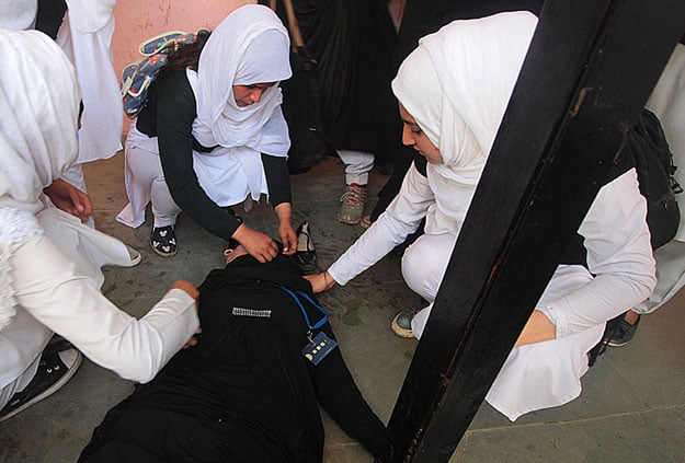 A student lies unconscious after inhaling chilli and tear smoke used by Indian police inside her college in Srinagar. PHOTO COURTESY: AL JAZEERA 