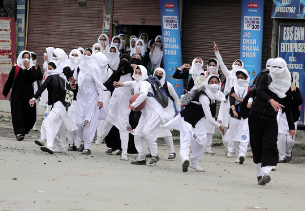 Female students in Srinagar throw rocks at police during clashes in Indian-occupies Kashmir. PHOTO: EPA