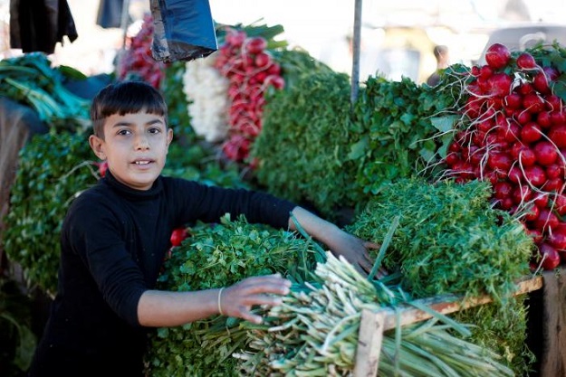 Falah, 11, sells vegetables and fruits in a market in eastern Mosul, Iraq. PHOTO: REUTERS