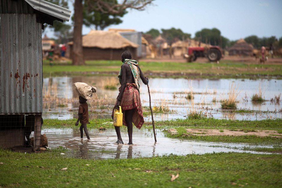 A woman with a boy walk in a flooded area in Panthau, Northern Bahr al Ghazal, South Sudan. PHOTO: AFP